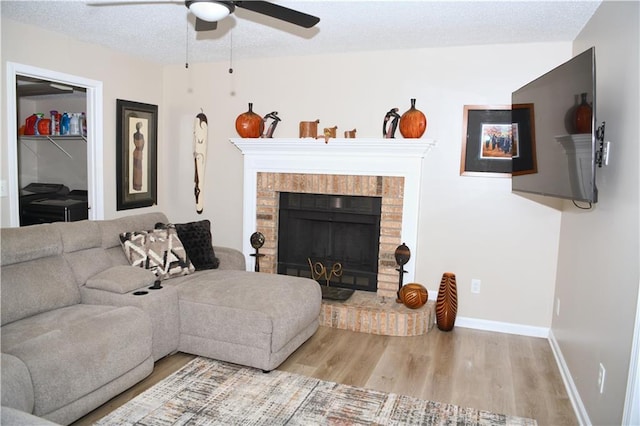 9130 Charlton Pl, Douglasville, GA 30135 - living room featuring wood finished floors, a ceiling fan, and a brick fireplace