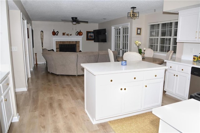 9130 Charlton Pl, Douglasville, GA 30135 - kitchen featuring ceiling fan, white cabinetry, light wood-style flooring, light countertops, and a textured ceiling