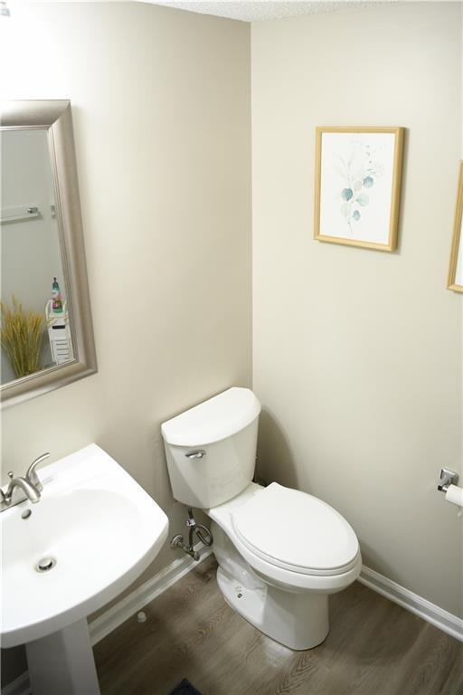 9130 Charlton Pl, Douglasville, GA 30135 - half bathroom featuring toilet and wood finished floors