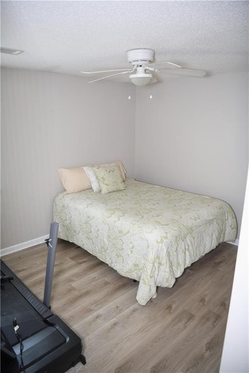 9130 Charlton Pl, Douglasville, GA 30135 - bedroom featuring wood finished floors, a textured ceiling, and a ceiling fan