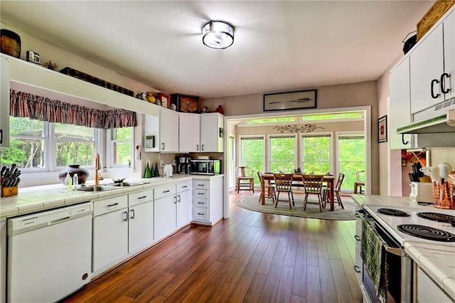 kitchen with white appliances, a sink, tile countertops, white cabinetry, and dark wood finished floors
