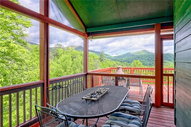 wooden terrace featuring outdoor dining area and a mountain view