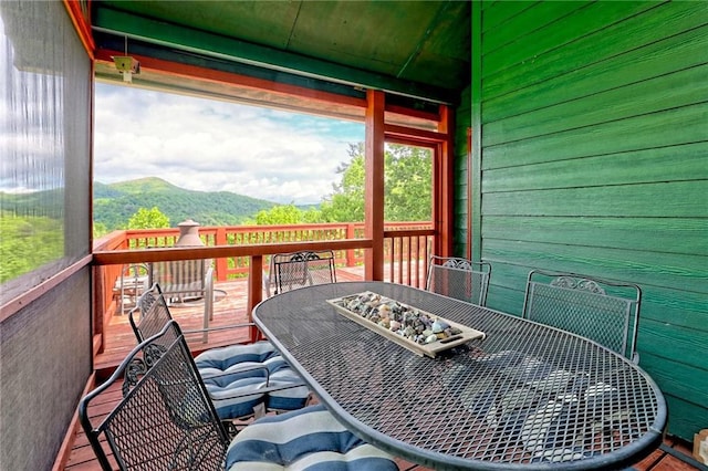 sunroom / solarium with outdoor dining space and a mountain view