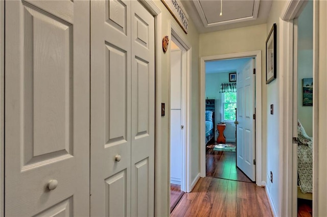 hallway with wood finished floors and baseboards