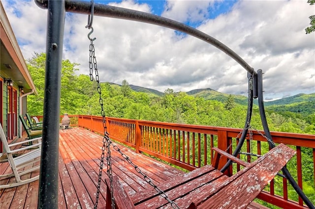 wooden terrace featuring a view of trees