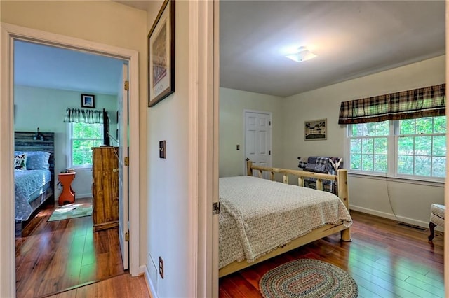 bedroom with hardwood / wood-style floors and baseboards
