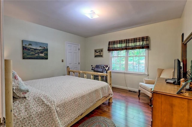 bedroom with dark wood-style floors and baseboards