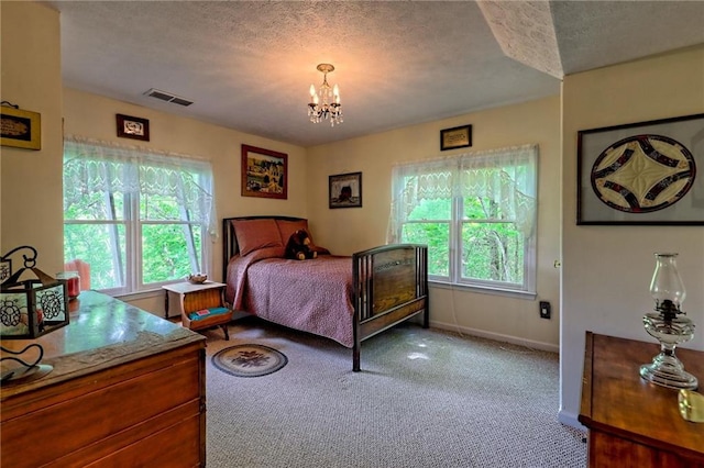 bedroom featuring a textured ceiling, a chandelier, carpet floors, and baseboards