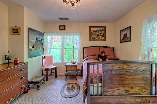 carpeted bedroom with a chandelier