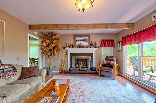 living room with wood finished floors, beam ceiling, and a tiled fireplace