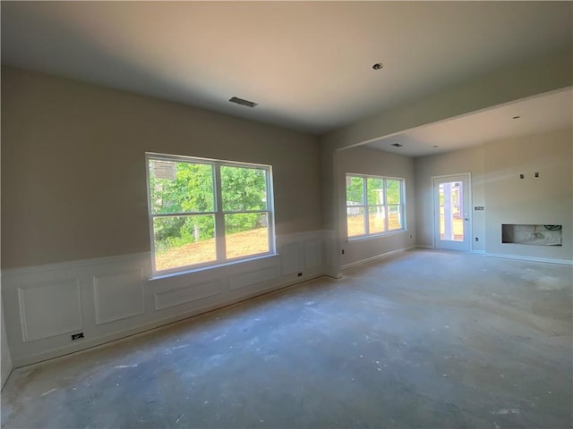 4678 Glore Rd SW, Mableton, GA 30126 - unfurnished living room featuring concrete flooring, a wainscoted wall, and a decorative wall