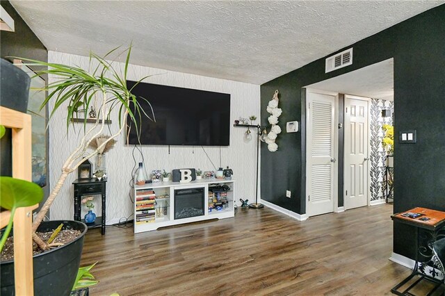 living room with dark wood-type flooring and a textured ceiling