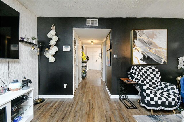 corridor featuring wood-type flooring and a textured ceiling