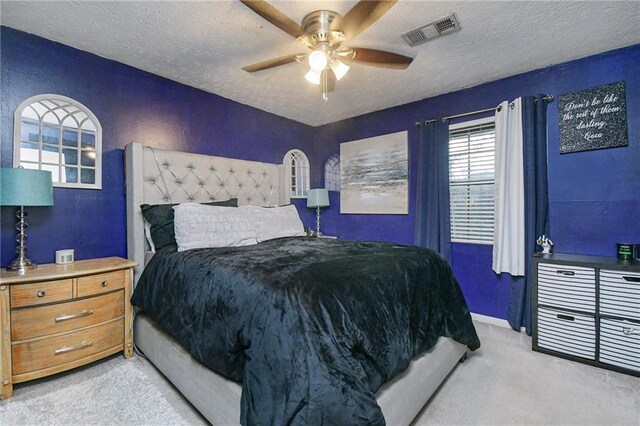 carpeted bedroom featuring a textured ceiling and ceiling fan