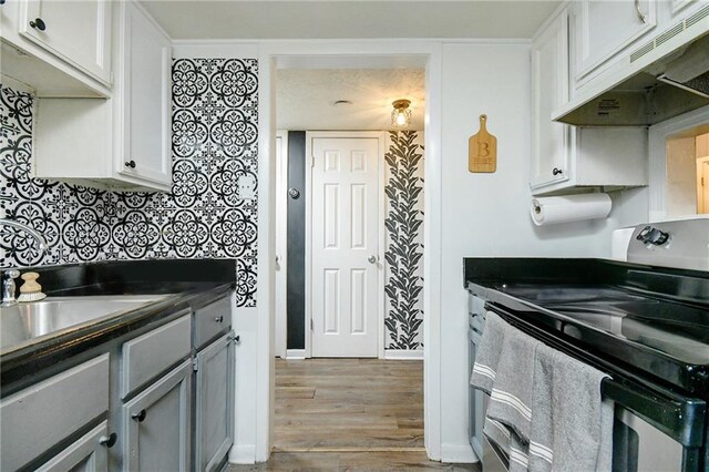 kitchen with light hardwood / wood-style floors, sink, white cabinets, gray cabinetry, and electric range