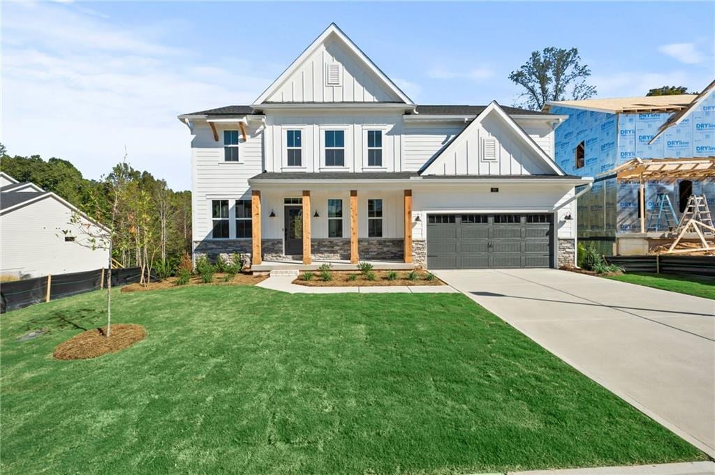 view of front of home with a garage, a porch, and a front lawn