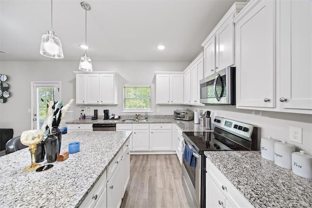 kitchen featuring appliances with stainless steel finishes, a sink, healthy amount of natural light, white cabinetry, and recessed lighting