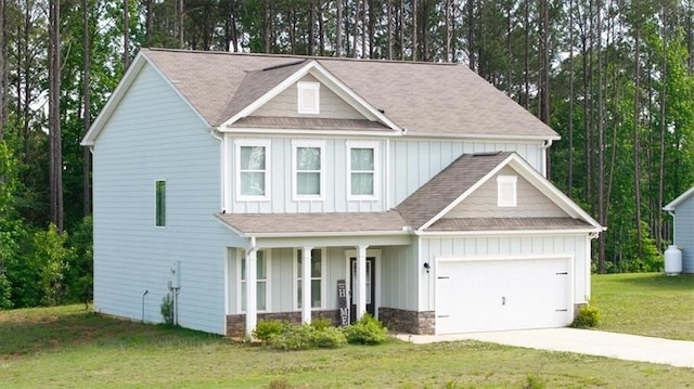 view of front of home with covered porch, board and batten siding, an attached garage, concrete driveway, and a front lawn