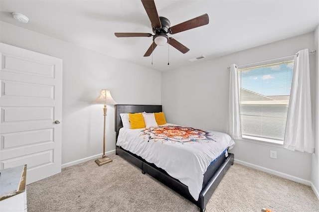 carpeted bedroom featuring baseboards and ceiling fan