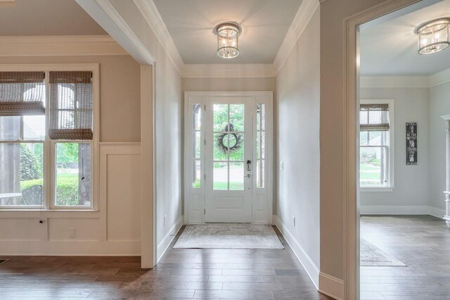 foyer entrance with wood-type flooring, a healthy amount of sunlight, and an inviting chandelier