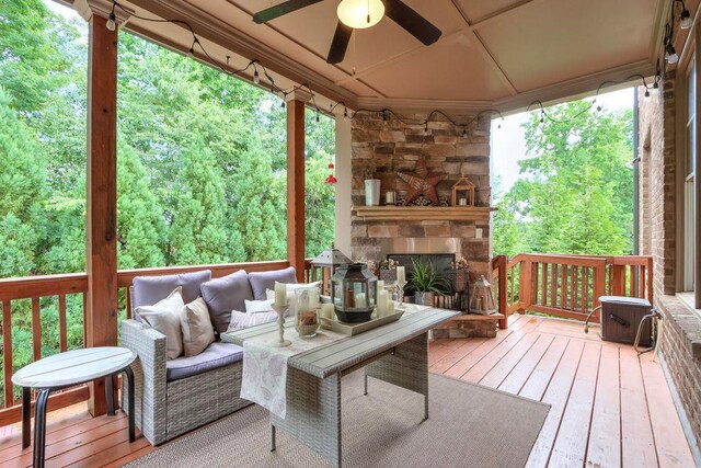 deck featuring a ceiling fan and an outdoor living space with a fireplace