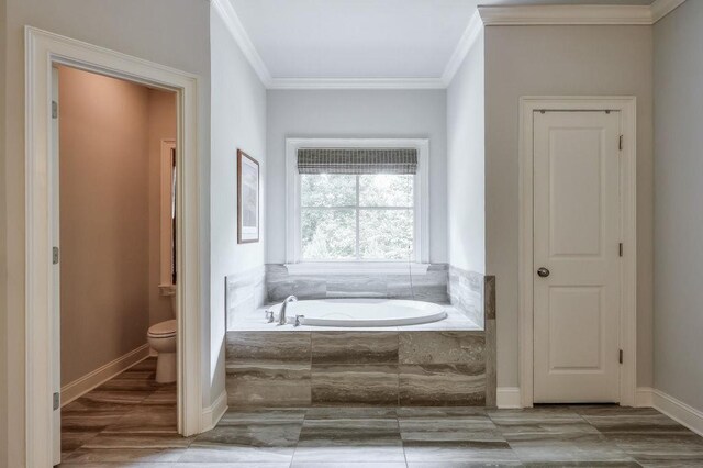 full bath featuring ornamental molding, a bath, and toilet
