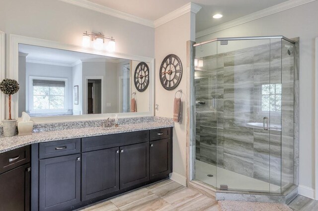bathroom with vanity, ornamental molding, baseboards, and a stall shower