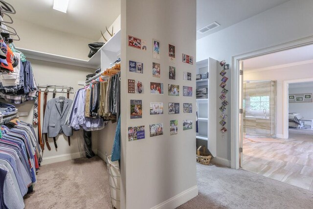 walk in closet featuring light carpet and visible vents