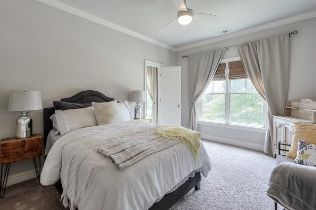 carpeted bedroom featuring crown molding, baseboards, visible vents, and ceiling fan