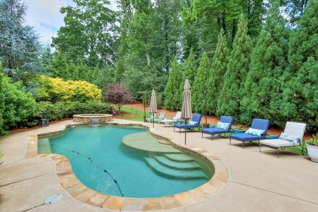 view of pool with a patio and a pool with connected hot tub