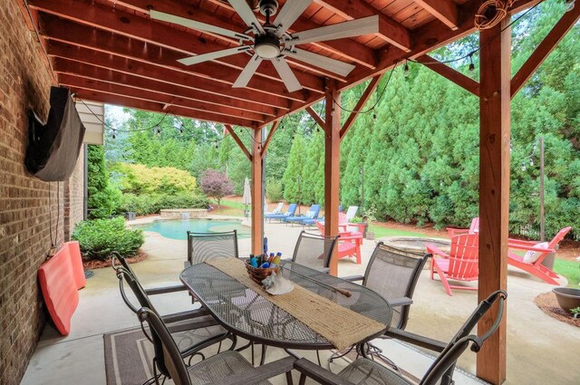 view of patio / terrace featuring ceiling fan, outdoor dining area, an outdoor pool, and an outdoor fire pit