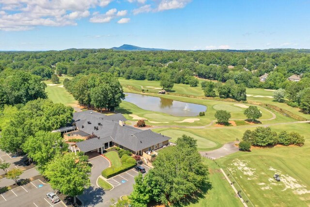bird's eye view featuring a water view, a view of trees, and view of golf course