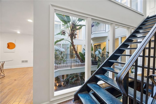 stairs featuring visible vents, baseboards, wood finished floors, and recessed lighting