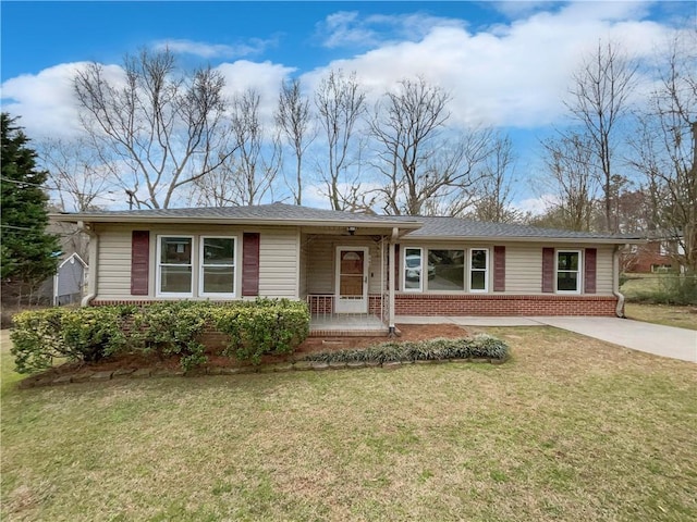 ranch-style house with concrete driveway, brick siding, and a front lawn