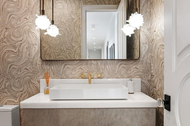 bathroom featuring wallpapered walls, toilet, and vanity