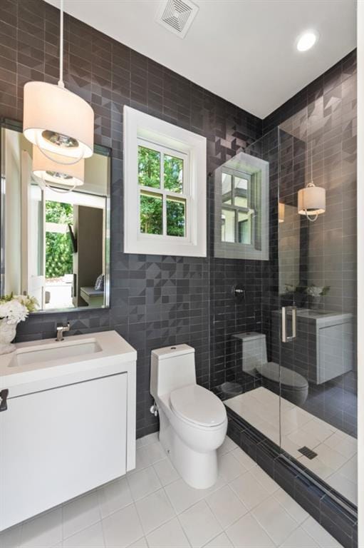 full bath with tile walls, toilet, tile patterned floors, a shower stall, and vanity