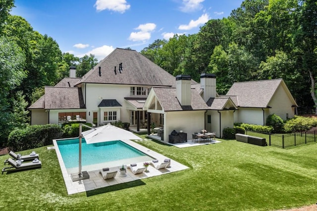 back of house featuring a chimney, stucco siding, and a patio area
