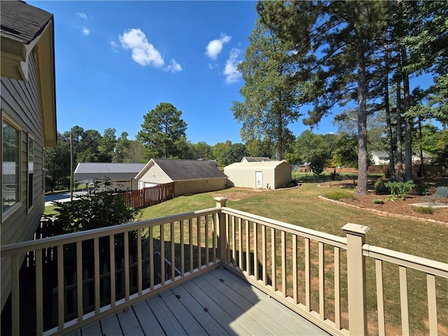 deck with a storage shed and a lawn