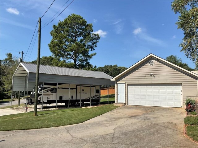 view of front of property with a carport, a garage, and a front yard