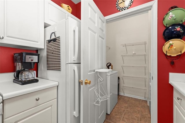 kitchen featuring light countertops, white cabinets, tile patterned floors, and freestanding refrigerator