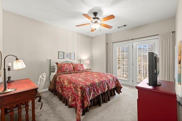 bedroom with access to exterior, visible vents, light colored carpet, and a textured ceiling