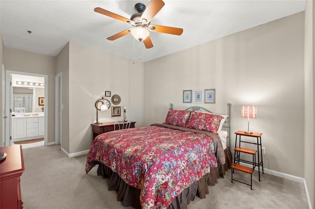 bedroom with ensuite bath, carpet, baseboards, and a textured ceiling