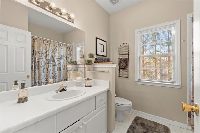 bathroom with vanity, visible vents, baseboards, tile patterned floors, and toilet