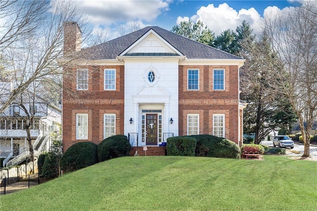 colonial-style house featuring a front yard