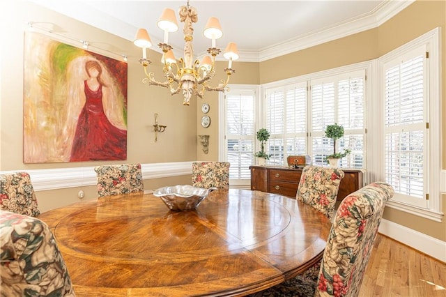 dining room with an inviting chandelier, crown molding, and light hardwood / wood-style floors