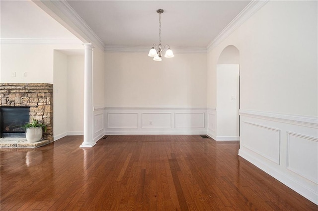 1935 Cobblestone Cir NE, Brookhaven, GA 30319 - unfurnished dining area with dark wood-style floors, a stone fireplace, a wainscoted wall, ornamental molding, and a chandelier