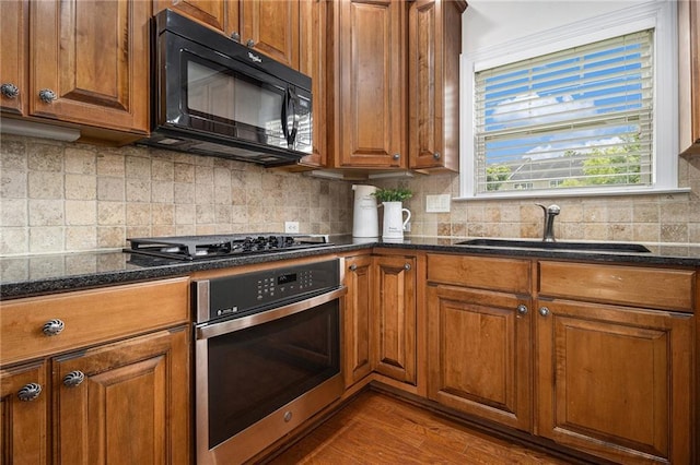 1935 Cobblestone Cir NE, Brookhaven, GA 30319 - kitchen featuring oven, black microwave, brown cabinets, and dark stone counters