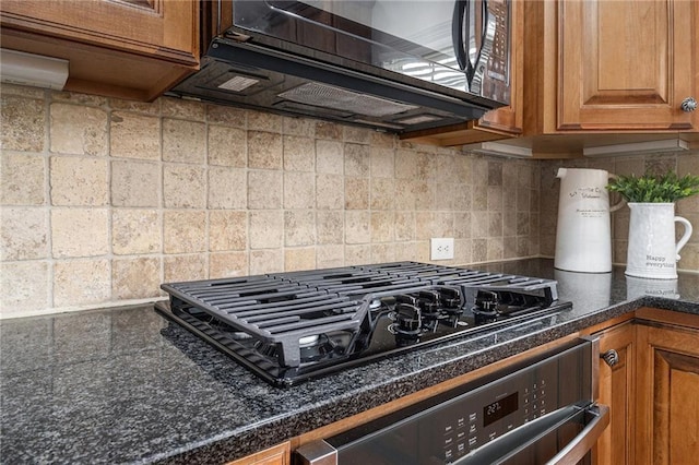 1935 Cobblestone Cir NE, Brookhaven, GA 30319 - kitchen view of black appliances, brown cabinetry, tasteful backsplash, and dark countertops
