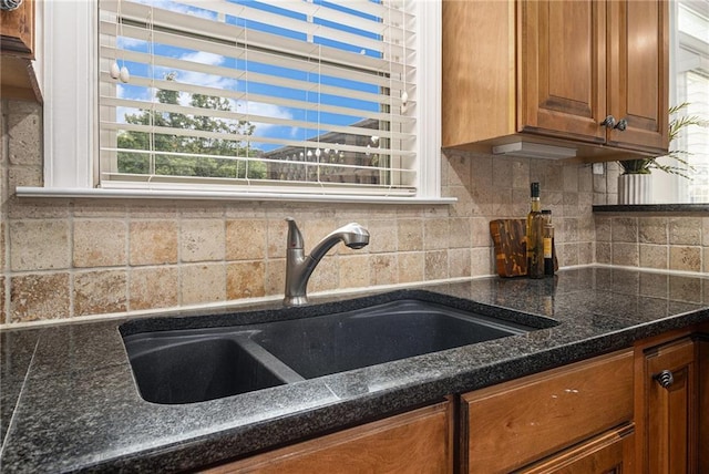 1935 Cobblestone Cir NE, Brookhaven, GA 30319 - kitchen with brown cabinetry, tasteful backsplash, and dark stone counters