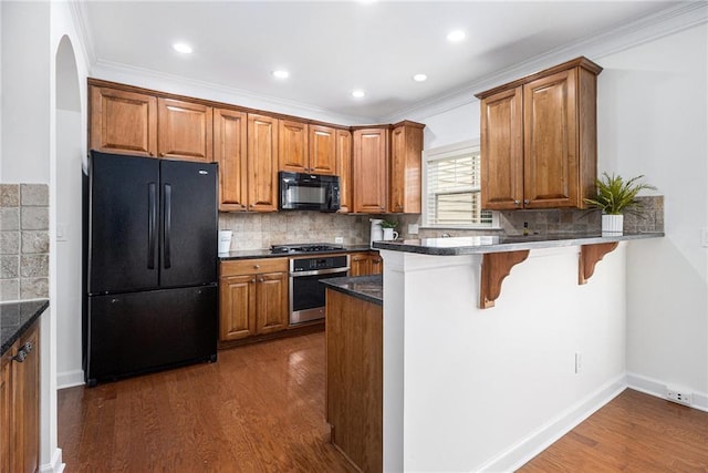 1935 Cobblestone Cir NE, Brookhaven, GA 30319 - kitchen featuring black appliances, brown cabinets, dark wood finished floors, crown molding, and recessed lighting